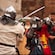 Two men dressed as knights fighting with swords